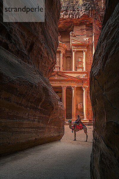 Al Khazneh (Die Schatzkammer) in Petra mit Beduinen und Kamelen im Morgengrauen