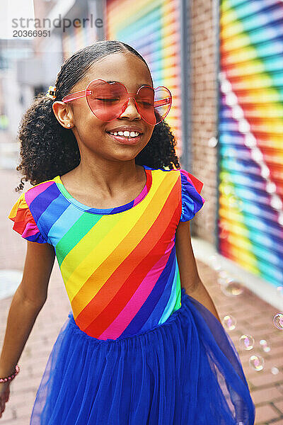 Junges Mädchen lächelt mit Blasen vor einem Wandgemälde in Washington  DC