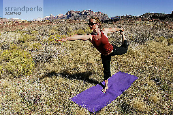 Eine Frau macht Yoga draußen in Springdale  Utah.