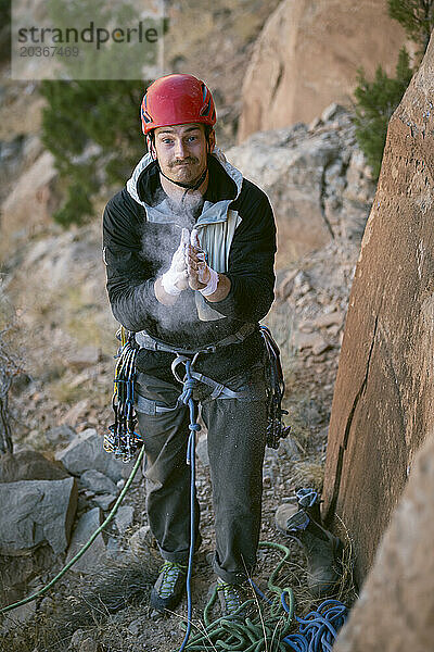 Mann mit Pulver in der Hand bereitet sich auf das Klettern in der Wüste vor