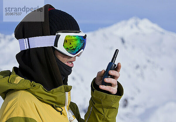 Nahaufnahme eines Snowboarders  der im Radio spricht  um sicherzustellen  dass der Filmer am Cerro Catedral bereit ist