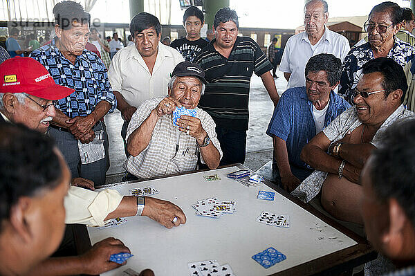 Männer spielen Karten.