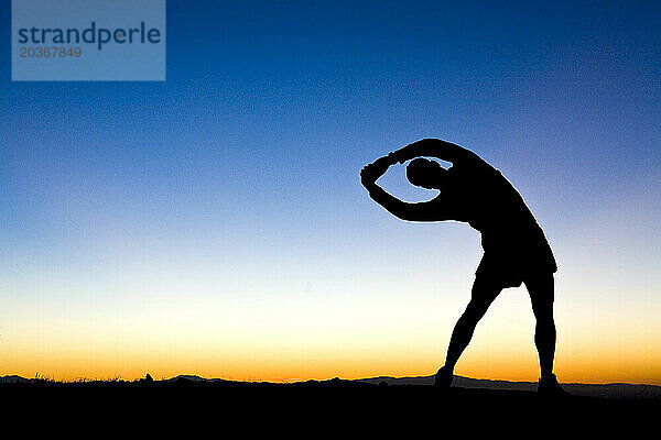 Eine Silhouette einer Person  die sich streckt