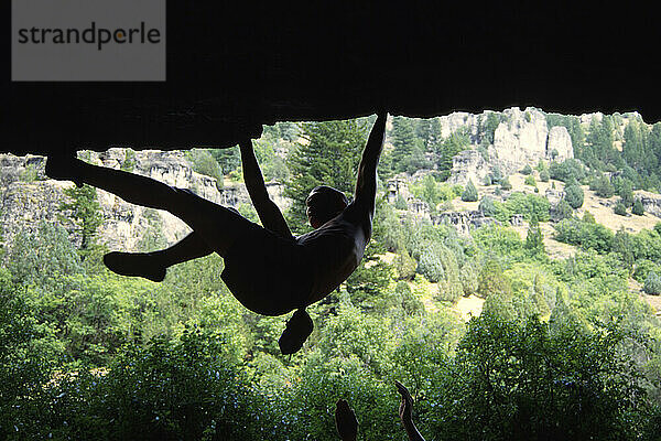 Mann (nicht identifizierbar) beim Bouldern unter einem Dach im Logan Canyon  Utah. (Silhouette).