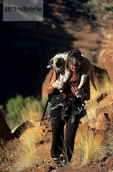 Frau wandert mit ihrem Hund im Indian Creek Canyon Rims Recreation Area  Utah.