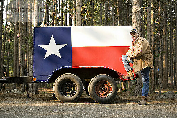Ein Mann posiert vor seinem individuell bemalten Anhänger mit der Texas-Flagge in Wyoming.