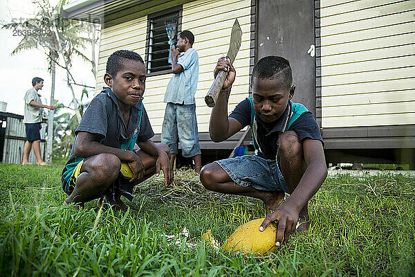 Lokale Kinder in Fidschi spielen vor dem Rasen des Hauses