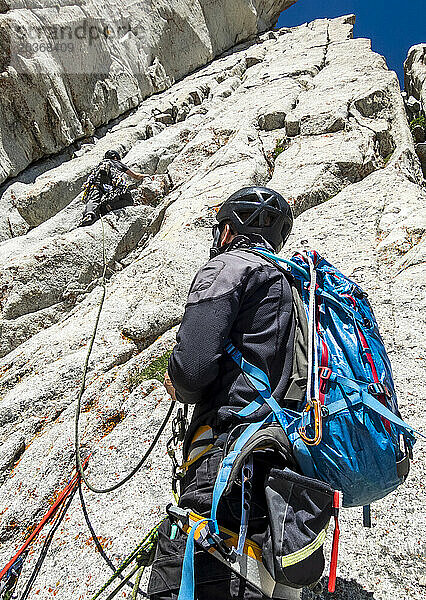 Mann schaut seinem Freund beim Klettern auf den Felsen in den Wasatch Mountains  Utah zu