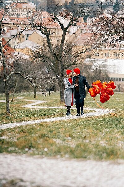 Junges Paar geht mit Luftballons im Herzen durch Prag