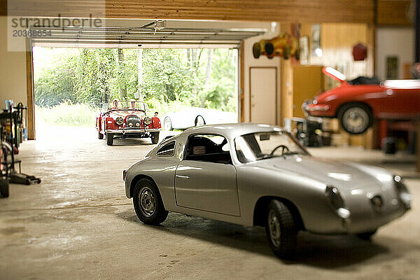 Ein Paar fährt mit seinem antiken Sportwagen zusammen mit anderen Autos in eine Garage in Pennsylvania.