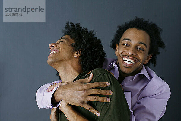 Zwei afroamerikanische Brüder umarmen sich.