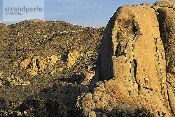 Zwei Männer klettern auf die Felskuppel im Hidden Valley  Joshua Tree  Kalifornien  USA.