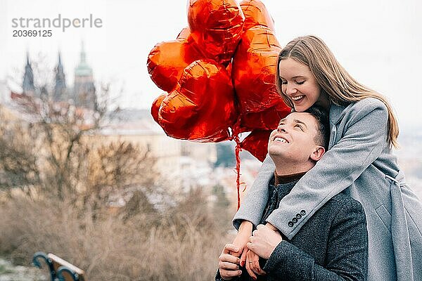 Junges Paar geht mit Luftballons im Herzen durch Prag