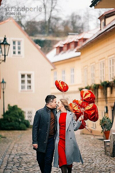 Junges Paar geht mit Luftballons im Herzen durch Prag