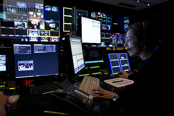 Eine Frau arbeitet an einem von Monitoren umgebenen Computer im Kontrollraum von ESPN in Bristol  Connecticut.