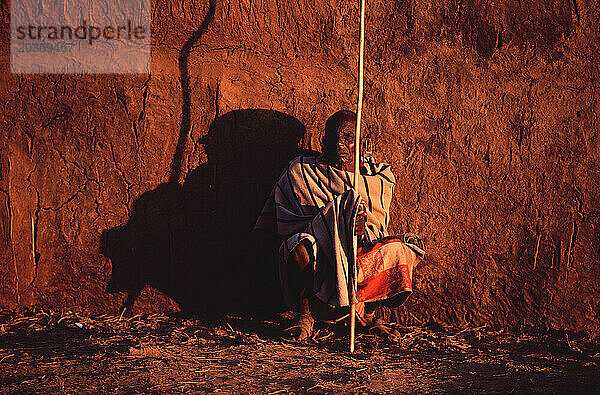 Ein Massai-Ältester ruht am späten Nachmittag an seiner Hütte im Großen Afrikanischen Grabenbruch im Süden Kenias.