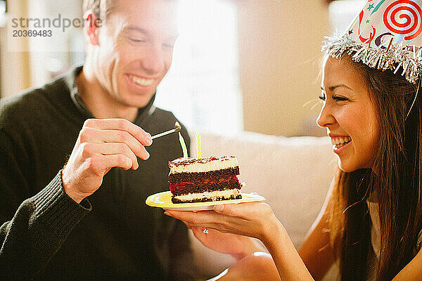 Junges Paar feiert Geburtstag mit Kuchen.