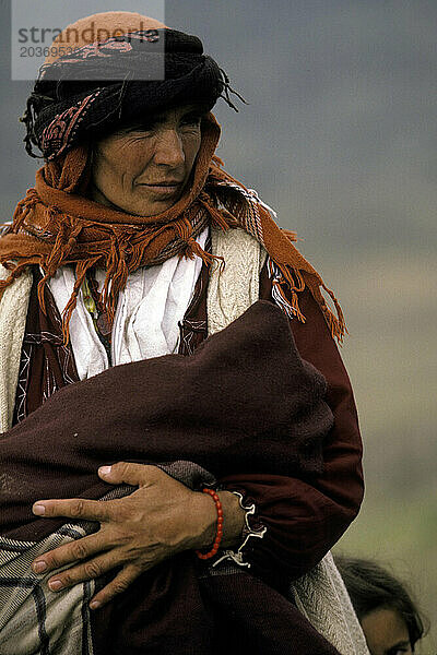 Eine indigene türkische Frau hält ein Kind in ihren Armen und schützt es vor dem rauen Wind.
