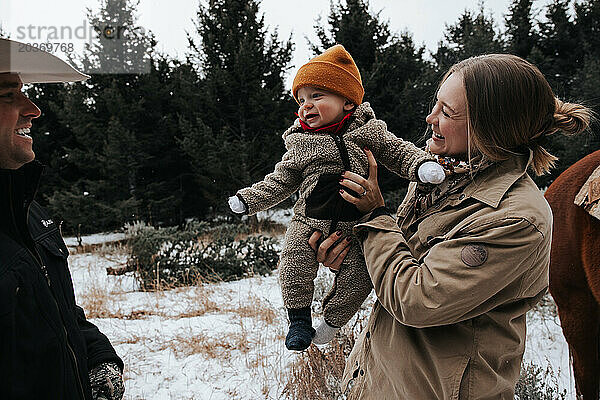 Lächelnde Familie draußen  nachdem sie den Weihnachtsbaum gefällt hat