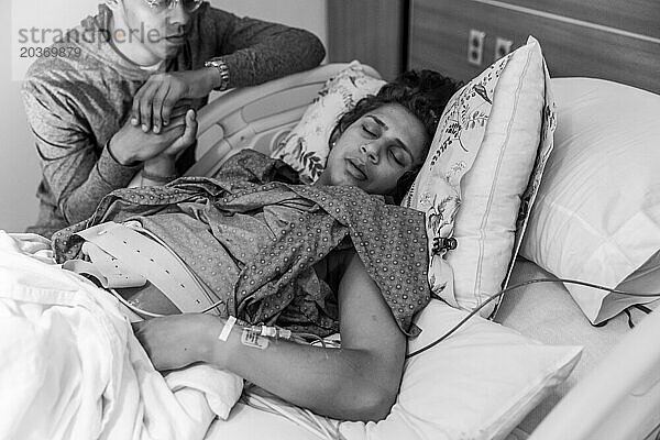 Müde indische Mutter schließt während der Wehe im Krankenhaus die Augen