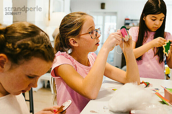 Mädchen aus gemischtrassigen Cousinen arbeiten gemeinsam an einem Bastelprojekt
