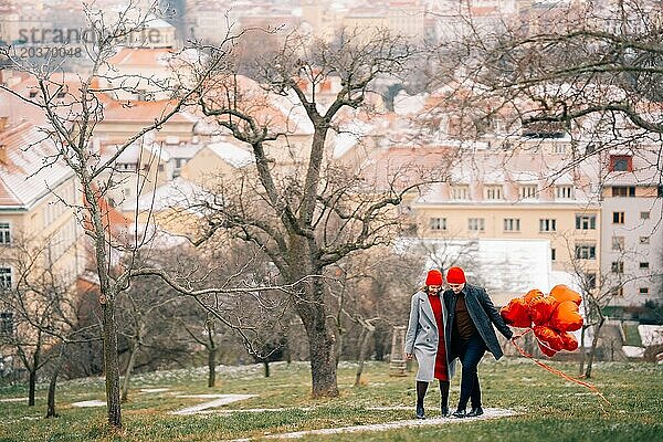 Junges Paar geht mit Luftballons im Herzen durch Prag