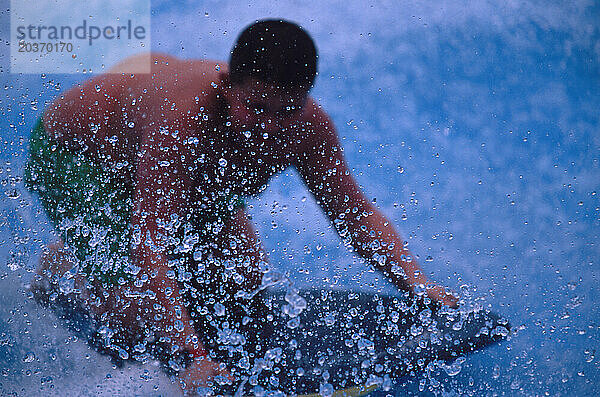 Ein Junge reitet auf einem Boogie-Board auf einer künstlichen Welle im Wasserpark Wild Wadi in Dubai  Vereinigte Arabische Emirate. Das gesamte Wasser im Park ist entsalzt  da es in den Vereinigten Arabischen Emiraten nur sehr wenig davon gibt
