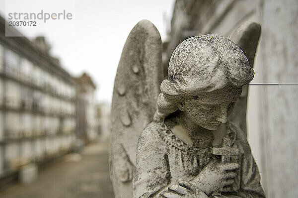 Eine Engelsstatue steht inmitten einst überfluteter Mauergewölbegräber auf dem St. Louis No. 1 Cemetery in New Orleans  Louisiana.