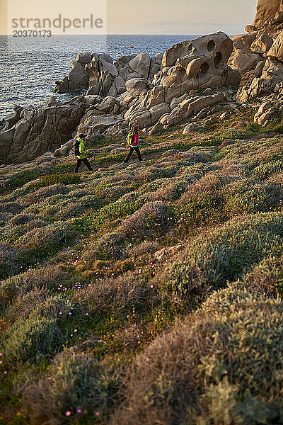 Blick auf ein Paar beim Wandern an der felsigen Küste  Sardinien  Italien