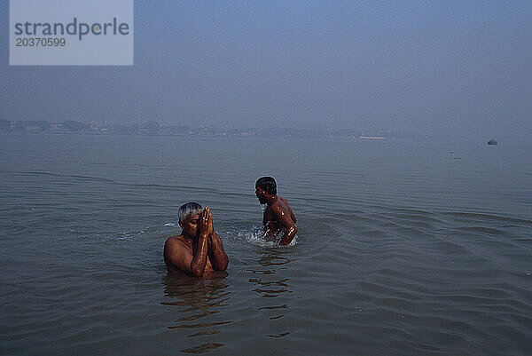 Männer waschen sich im Hooghly River am Judges' Ghat in Kalkutta  Indien. Der Fluss ist heilig  da das Wasser verschmutzt ist.