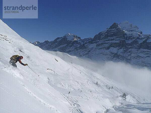 Ein Mann fährt im Skigebiet Grindelwald im Schweizer Berner Oberland eine Piste hinunter.