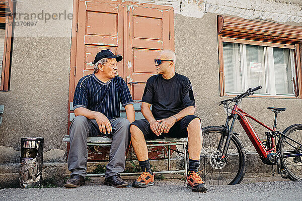 Alter und junger Mann teilen Erfahrungen bei E-Bike-Gesprächen