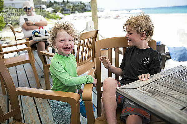 Glückliche Brüder sitzen auf der Terrasse der Caribbean Beach Bar