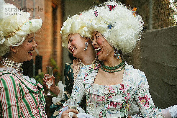 Frauen lachen während eines Abendessens im viktorianischen Stil.