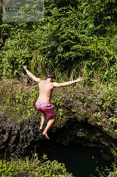 Klippensprung in ein üppiges Wasserloch auf der Road to Hana