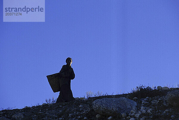 Silhouette einer Frau mit einem Korb  Dibleh  Nepal.