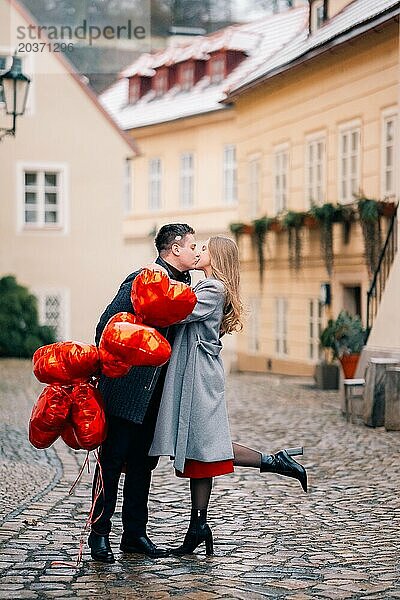 Junges Paar geht mit Luftballons im Herzen durch Prag