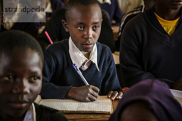 Tansanische Studentin sitzt am Schreibtisch in der Schule