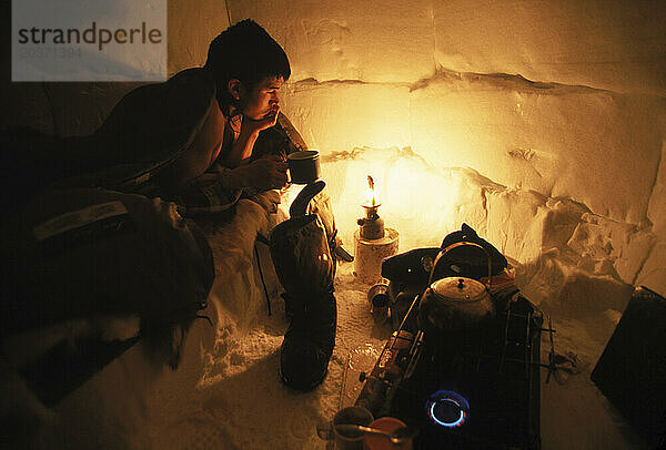 Mann sitzt während der Jagd im Iglu  Nunavut  Kanada