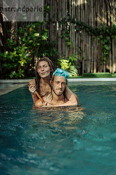 Glückliches junges verliebtes Paar im Pool im Urlaub in den Tropen.