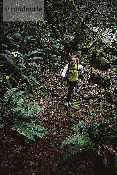 Eine Frau läuft beim Trailrunning im Wald.