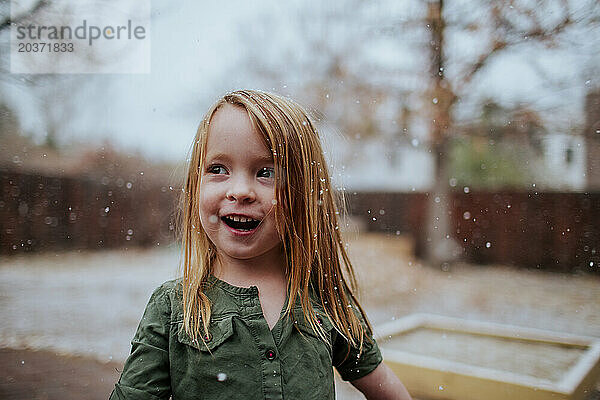 Mädchen im Vorschulalter lächelt draußen im Schnee
