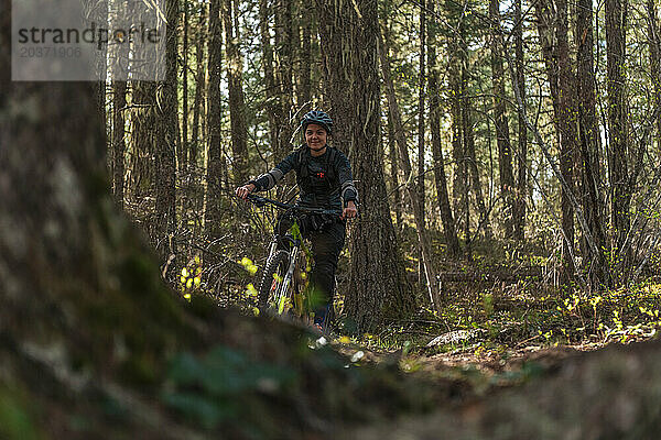 Lächelnde Frau beim Mountainbiken im Wald