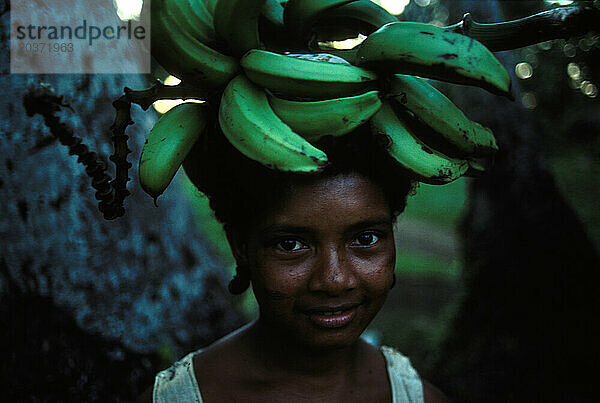 Frau trägt Bananen