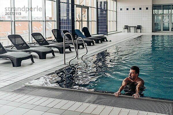 Ein 40-jähriger Mann schwimmt in einem Pool mit Blick auf Prag