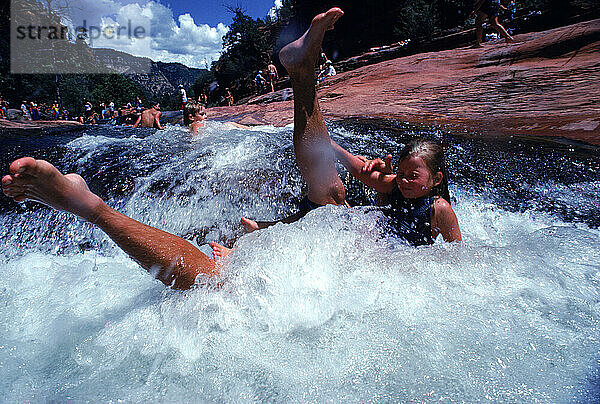 Menschen planschen auf der natürlichen Wasserrutsche Slide Rock in Sedona  Arizona.