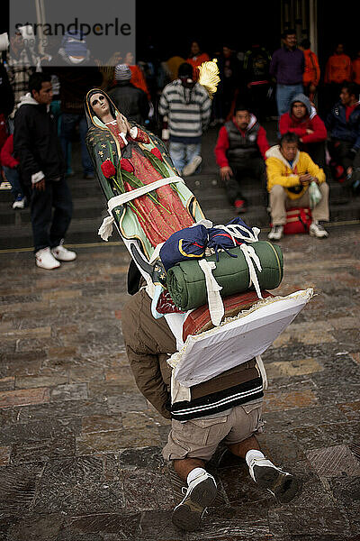 Ein Pilger geht mit einem Bild der Jungfrau von Guadalupe während der jährlichen Wallfahrt zur Basilika Unserer Lieben Frau von Guadalupe