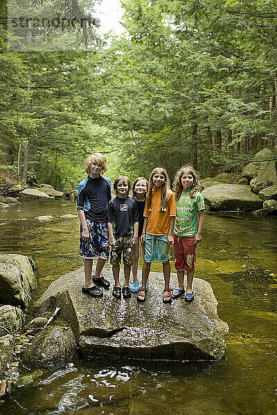 Eine Gruppe Kinder im Alter von 6 bis 10 Jahren steht auf einem Felsen in einem Fluss in den White Mountains  New Hampshire.