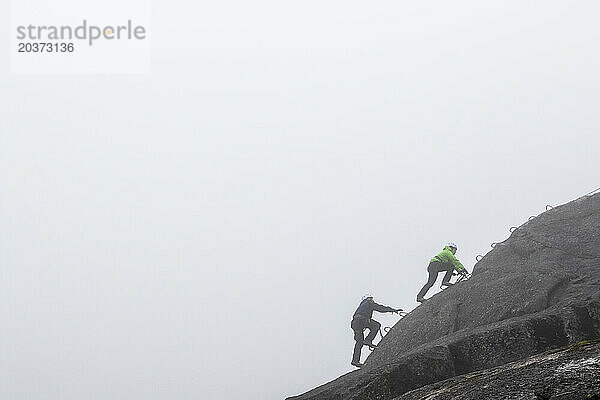 Eine Gruppe von Menschen genießt an einem regnerischen Herbsttag einen Klettersteig in Squamish  British Columbia.