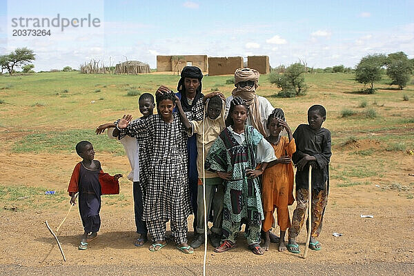 Eine Gruppe roter und schwarzer Tamashek-Kinder steht vor ihrem Lehmhaus in der Sahelzone  nicht weit von Doro in der Region Timbuktu  Mali  Westafrika